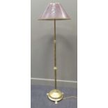 An early 20th century brass adjustable standard lamp on a circular base with paw feet, 162cm high