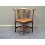 An 18th century elm seated corner chair, the outscrolling arms over pierced rectangular splats and