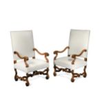 A pair of French Louis XIV style walnut open arm chairs,