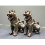 A pair of Eastern carved wood mythical dogs with applied sequin decoration, 88cm high (2)