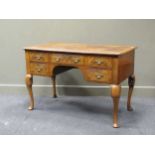 A walnut revival dressing table, the rectangular top over an assortment of five drawers raised on