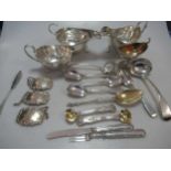 A collection of silver flatware, mainly spoons, together with three silver sauce boats, three silver