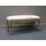 A Louis XV style gilt rectangular stool with cream damask upholstery, 49.5 x 97 x 40cm