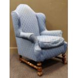 A William and Mary style walnut wingback armchair, the arched back above pair of outscrolling arms