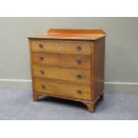 An Edwardian mahogany chest of drawers, the raised back above four long graduating drawers with ring