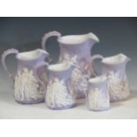 A set of five graduated Sam Alcock and Co Ironstone relief moulded jugs, depicting battle scenes,