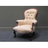A Victorian spoon back walnut framed armchair on cabriole legs with button back floral upholstery,