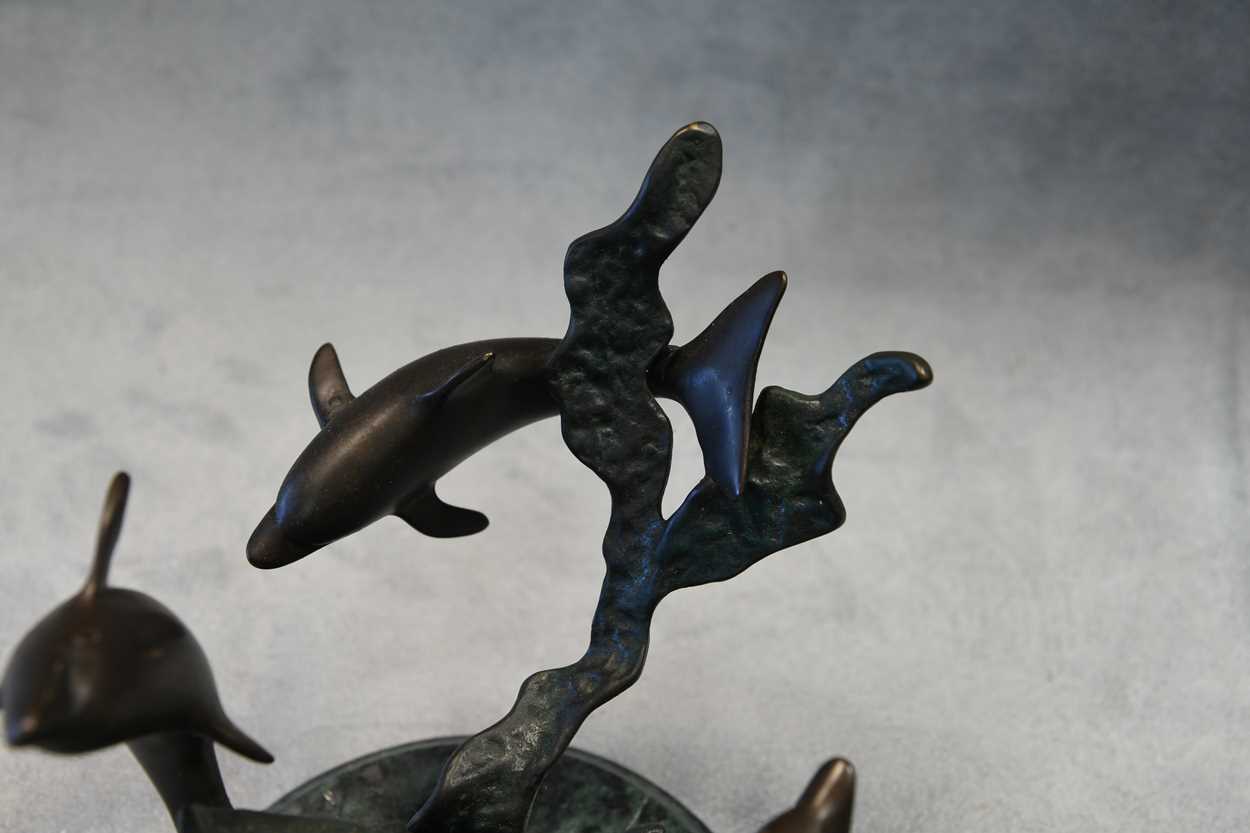 A bronze model of three swimming dolphins, the patinated model mounted to a green marble plinth - Image 7 of 8