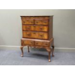 A George II style figured walnut chest on stand with six drawers over shell carved cabriole legs