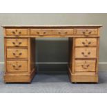 An oak pedestal desk with a leather top comprising of nine drawers, 73.5 x 123 x 65cm