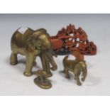 Four miniature elephant figurines, three brass and one wooden