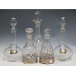 A group of cut glassware including five decanters, a silver coaster, two decanter labels and various