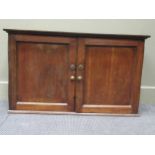 An oak cabinet, the two panelled doors enclosing shelves and drawers 58 x 98 x 33cm