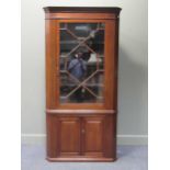 A Georgian style mahogany barrel back corner cabinet, the astragal glazed door over a two door