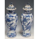 A pair of Chinese blue and white vases and covers, 33cm (damaged)Both lids have loss and visible