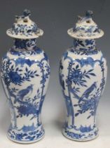 A pair of Chinese blue and white vases and covers, 33cm (damaged)Both lids have loss and visible