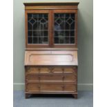 Circa 1920, an oak lead glazed two door bookcase/ bureau, 187 x 108 x 45cm