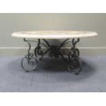 A marble topped circular coffee table on wrought iron scrolled base, 47cm high and 112cm diameter