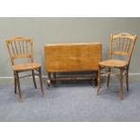 A late 19th century oak Sutherland table, together with four spindle back bedroom chairs with floral