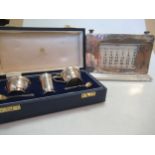 A cased silver three piece cruet set together with a silver fronted desk calendar,