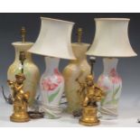 A pair of cream lamps decorated with lilies; another smaller set with tulips painted on; together