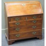 A George III mahogany bureau with brass handles and attachments, the lower section with three long