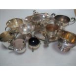 A two handled silver trophy cup, together with a silver bon bon dish and a silver cream and sugar,