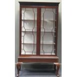 A 19th century Chippendale style glazed mahogany cabinet on stand, the Greek key moulded cornice