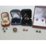 Two hallmarked 9ct gold garnet rings, a topaz ring tested as 9ct gold, and a pair of topaz ear studs