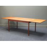 A 1950’s hardwood rectangular dining table, possibly by Borge Mogensen, with drop-leaf ends, on four