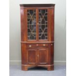 A George III style mahogany two section corner cupboard, 204 x 107cm