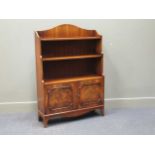 A Bevan & Funnell Georgian style mahogany waterfall bookshelf with two door cupboard, 121 x 83 x