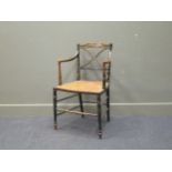 A pair of Regency ebonised and gilt decorated chairs, with key fret top-rails and ‘X’ back splats