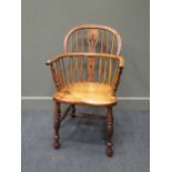 A Windsor armchair on turned legs united by a H-shaped stretcher