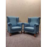 zzz A pair of blue upholstered wingback armchairs (2)