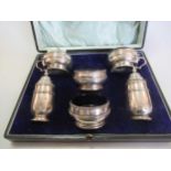 A cased silver 6 piece cruet set along with a cased set of 4 silver salts with silver spoons and a