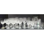 A large collection of modern glass wares, including decanters, wine glasses, tumblers, a jug, and