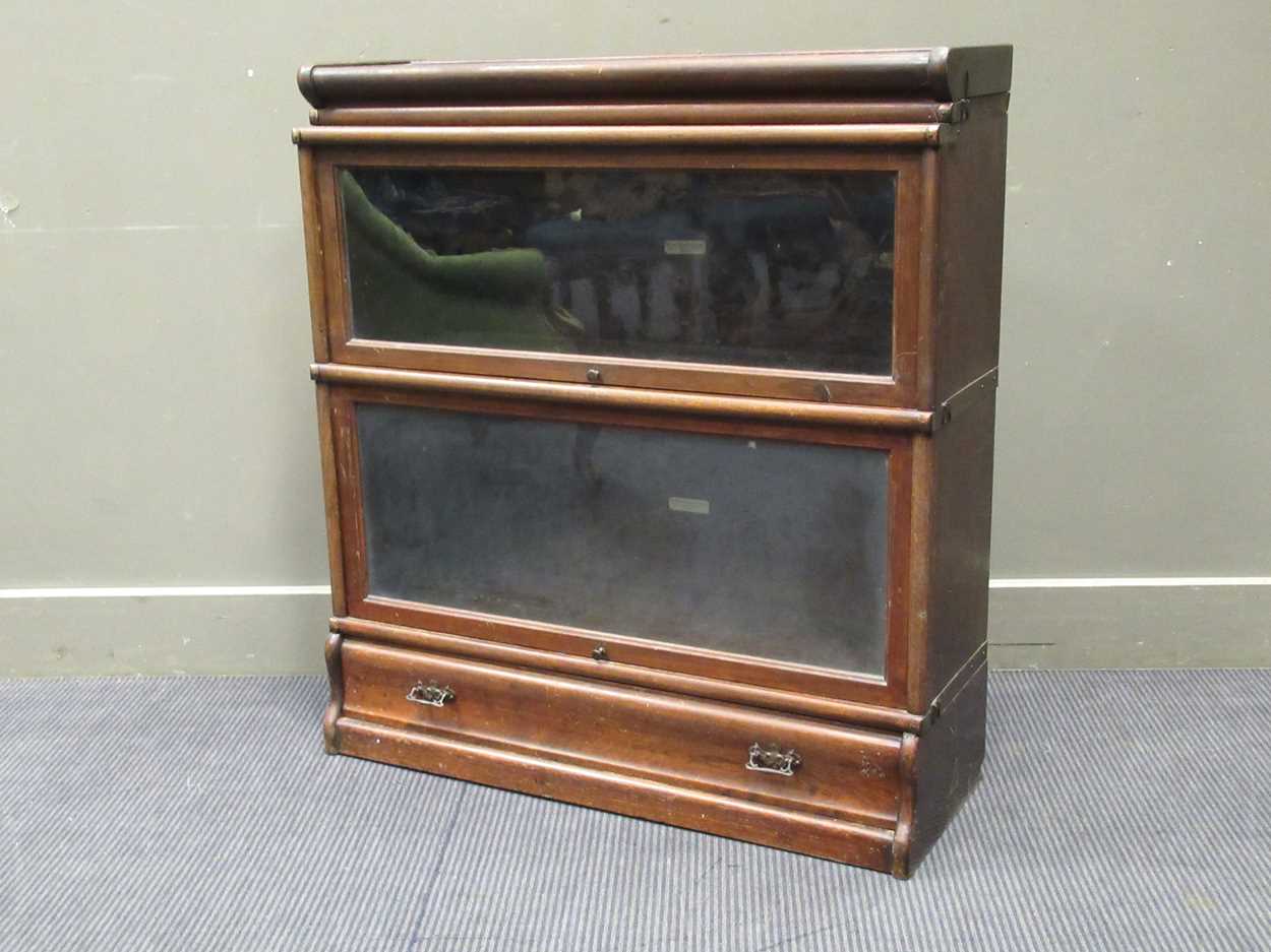 A Globe Wernick sectional bookcase, comprising of two glazed sections on a single drawer base, 95