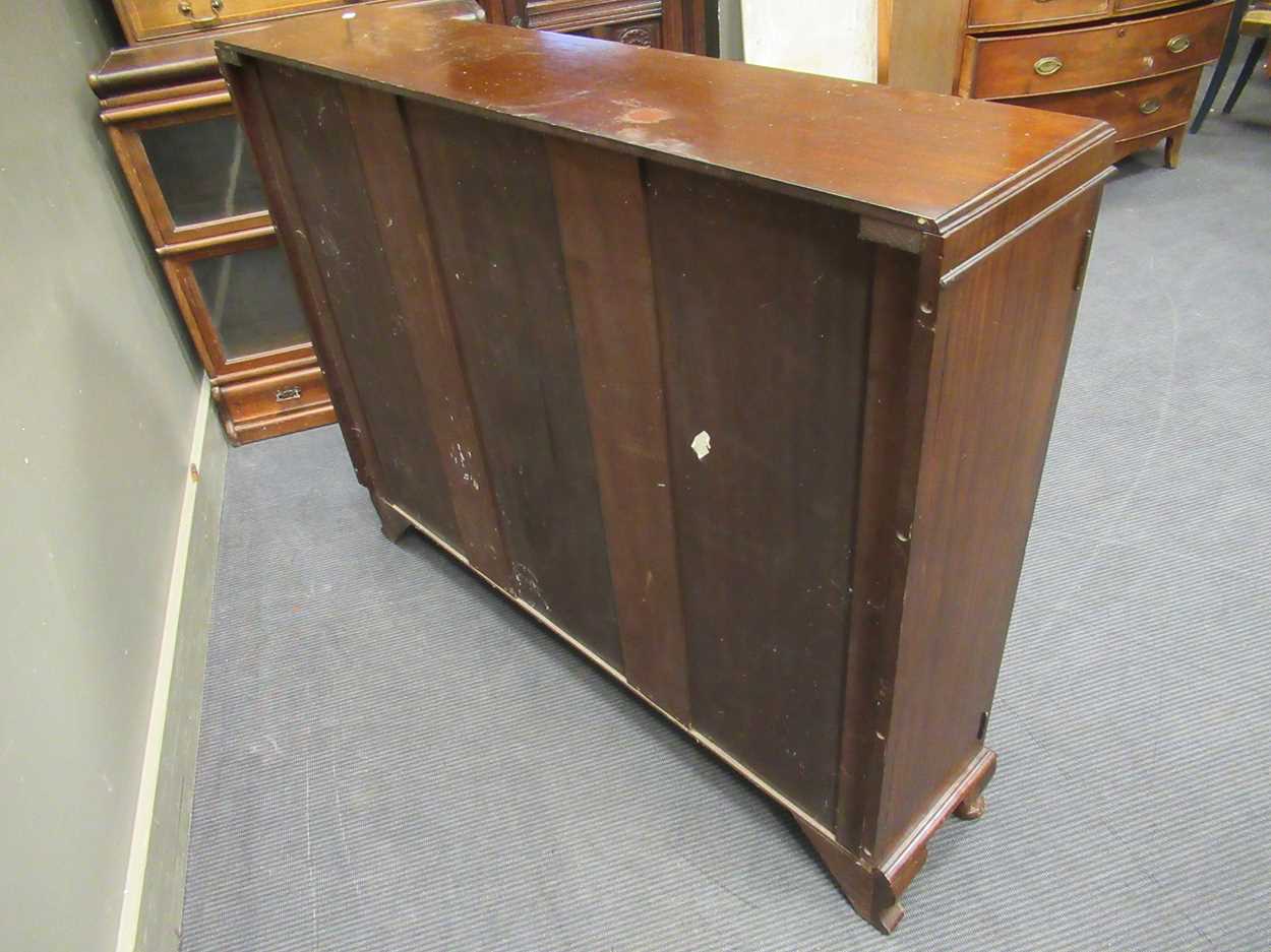 A 1920s mahogany low bookcase cabinet with central cupboard door flanked by a pair of glazed - Image 3 of 5