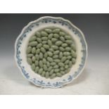 An 18th century Moustiers faience trompe l'oeil 'green olives' plate having a scalloped shaped and