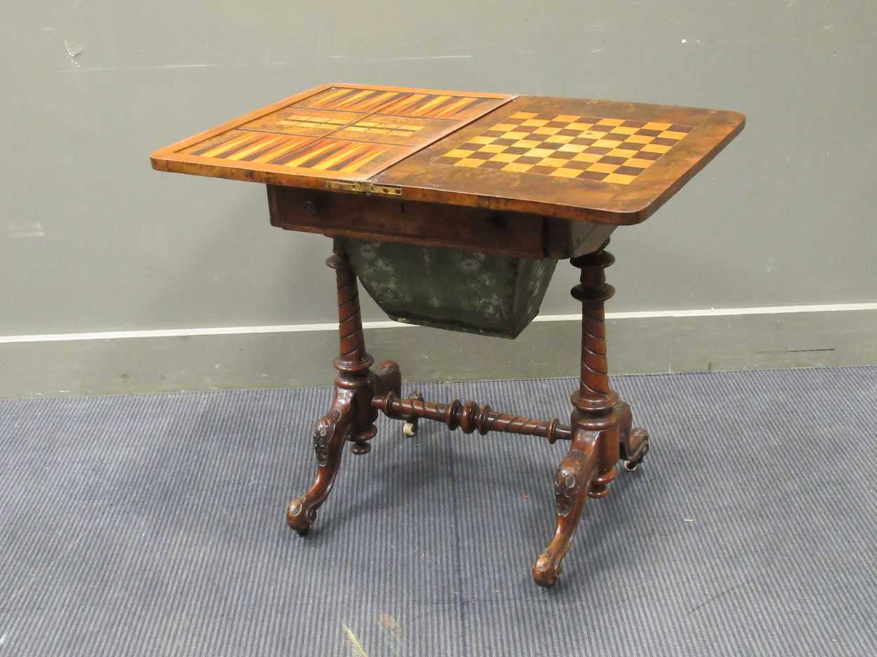 A Victorian walnut inlaid fold over games table, the fold over top enclosing an inlaid backgammon