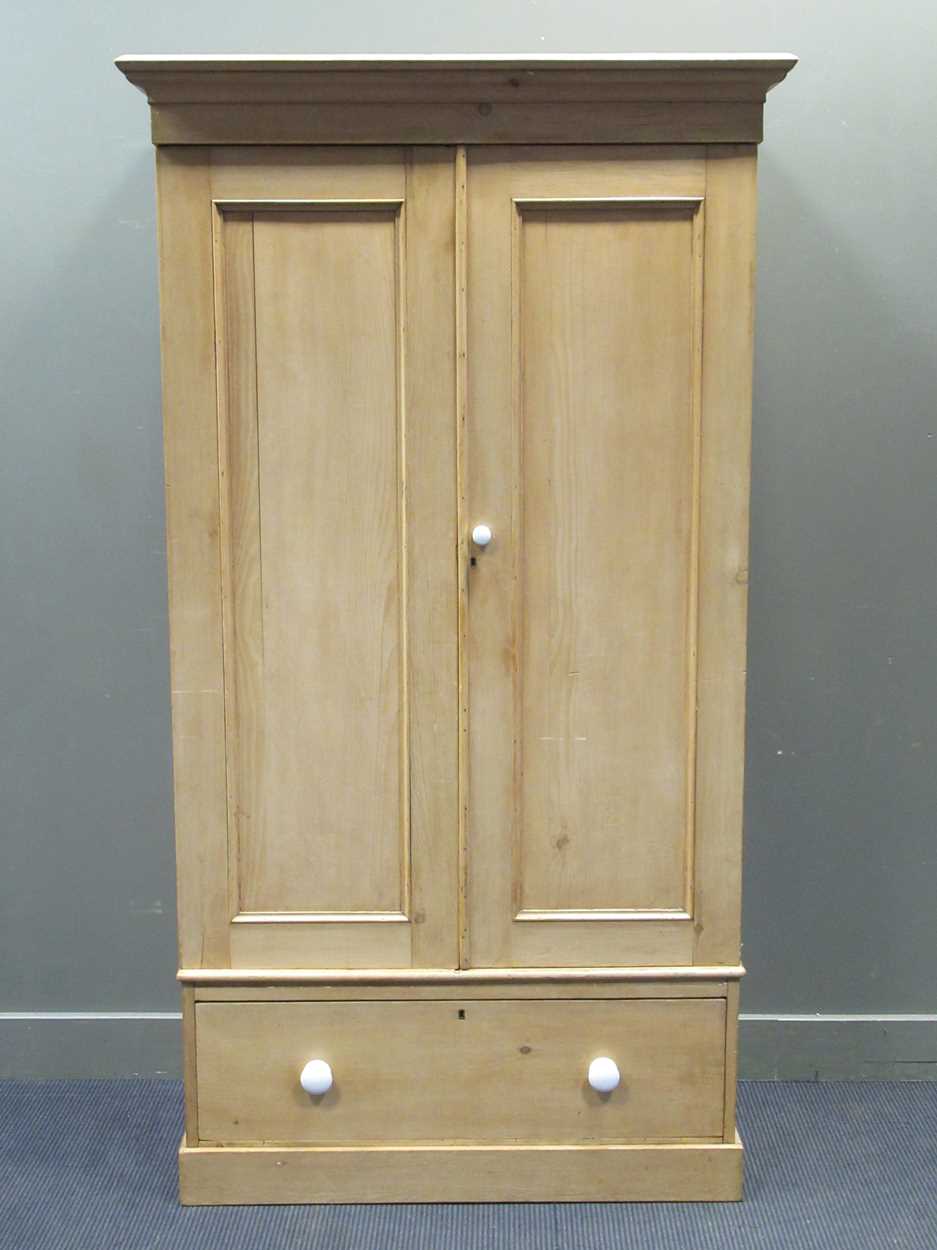 An early 20th century pine two-door wardrobe with drawer to base 207 x 114 x 58cm
