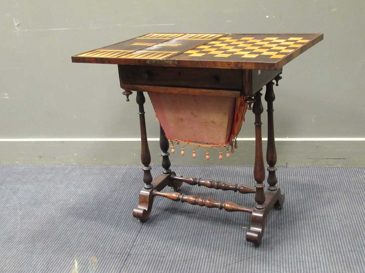 A 19th century inlaid rosewood games table, the fold over swivel top enclosing an inlaid