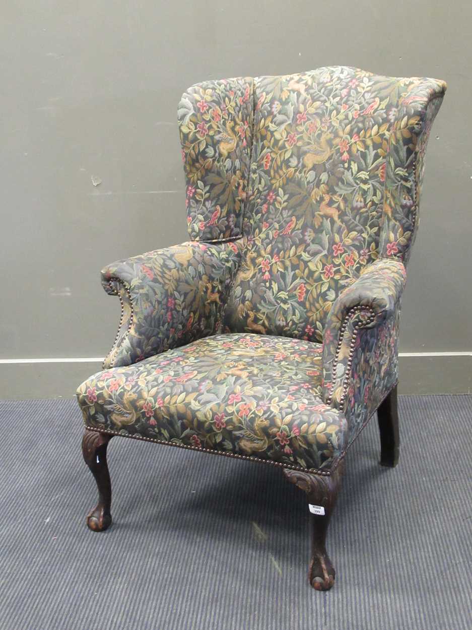 A wingback armchair upholstered in William Morris style fabric on cabriole front legs