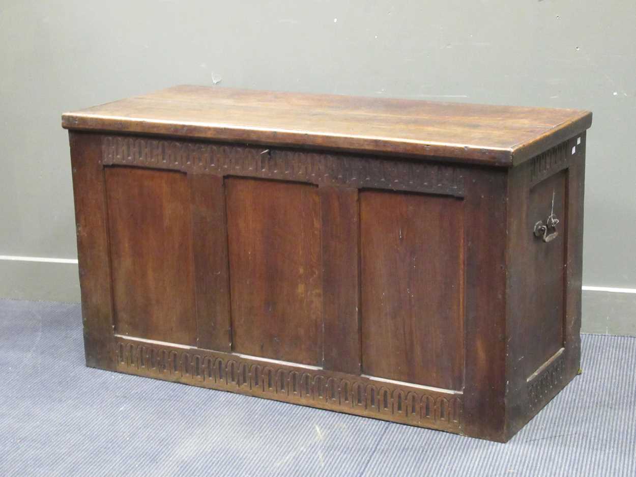 A large oak coffer in the 17th century style with nulled carved frieze and three panel front and