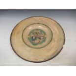 A continental pottery plate, the centre moulded with coats of arms, 35cm diameter