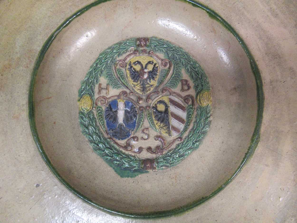 A continental pottery plate, the centre moulded with coats of arms, 35cm diameter - Image 2 of 4