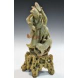 A Chinese soapstone figure of a deity with a lion, early 20th century,