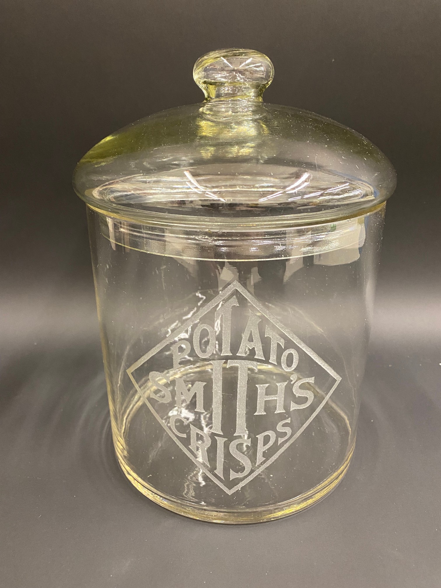 A Smith's Potato Crisps glass lidded dispensing jar, approximately 7" diameter.