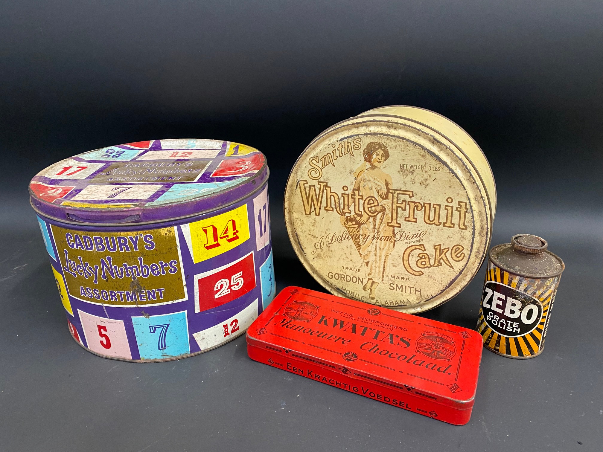 A Cadbury's Lucky Numbers Assortment tin, a Smith's White Fruit tin and two others.